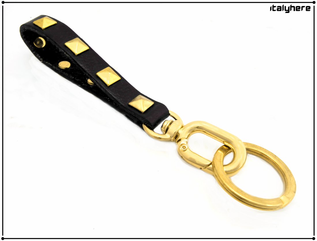 Leather keychain with pyramidal studs, 6 colors available, length 13 cm, gold finishes.