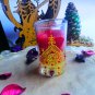 A transparent red cup of wax with shiny crystals