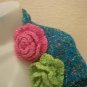 Knitted shrug in Turquoise with pink and green flowers on it.M size