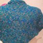 Knitted shrug in Turquoise with pink and green flowers on it.M size