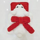 Handmade crochet plush teddy bear laying on soft pillow