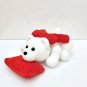 Handmade crochet plush teddy bear laying on soft pillow