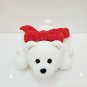Handmade crochet plush teddy bear laying on soft pillow