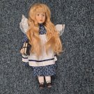 Porcelain Doll Alice Blonde Wavy Hair Blue Dress White Apron Holding Book Porcelain Doll Alice Blonde Wavy Hair Blue Dress White Apron Holding Book