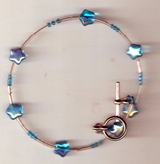 bracelet made of blue glass star shaped beads seed beads and bugle beads on memory wire.
