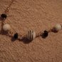 Black, white and gold glass, ceramic and metal bead necklace