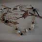 Black, white and gold glass, ceramic and metal bead necklace