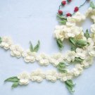 Hand-crochetted white peachblossom flowers scar f with green leaves